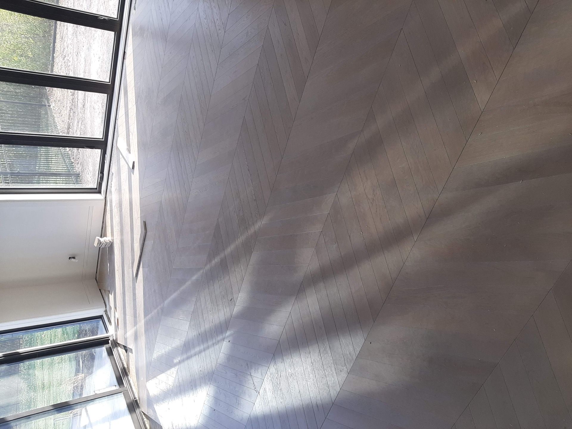 Chevron hardwood floor in a bright Niagara home